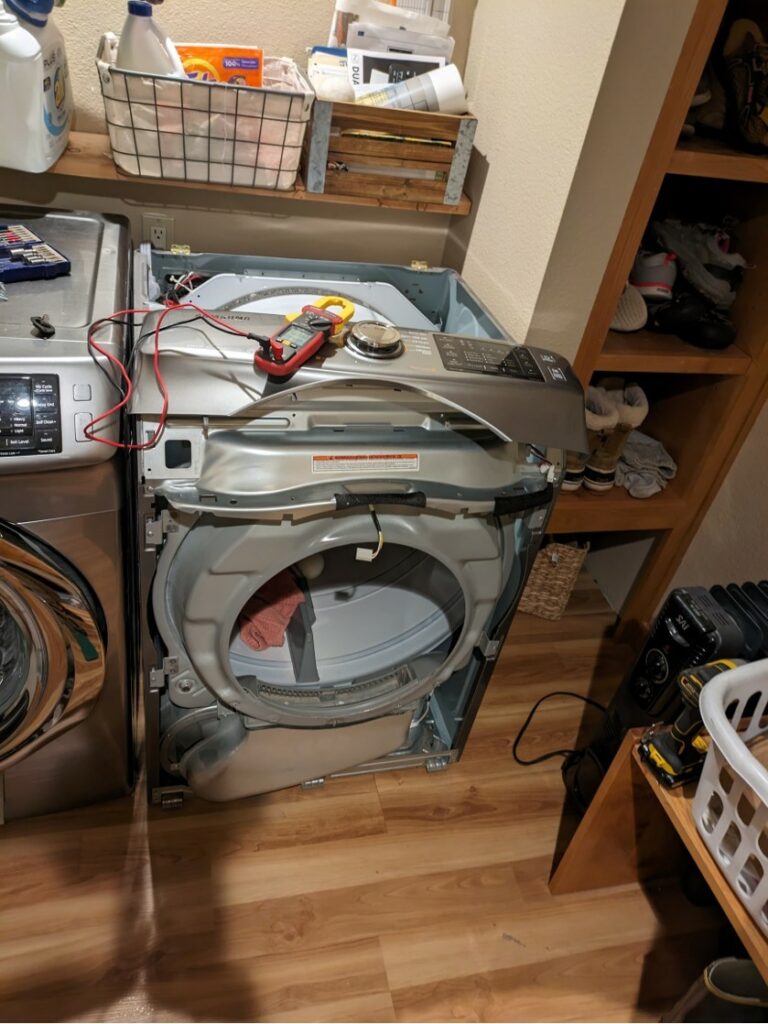 Dryer with panels removed and a diagnostic meter